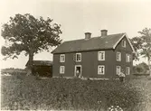 Arbetarbostad vid ladugården, ett rött, korsknutat timmerhus.