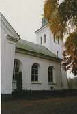 Dalhems kyrka, putsad fasad, valvfönster och kyrkogård. Foto från renoveringen 1993.