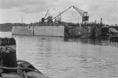 Ekensbergs varv 1970; varvskranar och flytdocka. Längst t h i stora dockan skymtar stäven på fartyget LINDÖ.