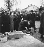 Grundstenen för Gävle Museum lägges 26 oktober 1938. Här ses borgmästatare Nils Berlin övervaka när en person håller i mursleven.