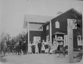 Större sällskap, utanför hus.