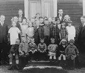 Större och yngre barn, uppställda för gruppfoto på trapphuset.