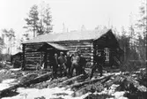 Skogsarbetare, utanför en stuga.