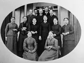 En grupp män och kvinnor uppställda för fotografering. ( Ett äldre fotografi).