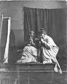 Ester Ellqvist (gift Bauer) och Signe i ett rum på Konstakademin i Stockholm. Uppkrupna på ett bord sitter de och äter äpple.