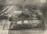Flygbild visande herrgården i bildens mitt. ill vänster en del av den gamla byn med gårdar byggda enligt vanligt ölandsmanér. Upptill till höger den berömda Västerstads almskog.