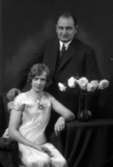 Ateljébild på en man och en kvinna lutandes mot ett bord med blomma. Enligt Walter Olsons journal är bilden beställd av herr A Berlin.