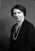 Ateljébild på en kvinna i halsband och klänning. Enligt Walter Olsons journal är bilden beställd av fröken Elsa Pettersson.