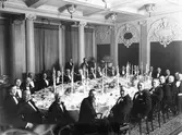 Gefle Stads Sparbanks middag på Grand Hotell. Denna bank startade 9 juni 1824 och med stor säkerhet är detta bankens 100 års jubileum 9 juni 1924. Jubileumsmiddagen hölls på just Grand Hotell och beskrivs i  Norrlandsposten dagen efter dvs den 10 juni.

Den vithårige mannen närmast i bild är fabrikören och styrelseledamoten Johan Erik Boberg. Fyra platser till höger om denne sitter blivande bankdirektören Fredrik Berg. På vänstra sidan i mitten tillfördordande landshövdningen Oscar Rydin. Rydin medverkade vid ovannämnda middag enligt tidningen. Till höger om Rydin sitter mycket troligt styrelseordförande Oscar Flensburg.
Källor: 
Norrlandsposten 10 juni 1924
Oscar Fyhrvall 
