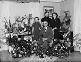 Familj omgiven av blommor i bostadsmiljö, Östhammar, Uppland