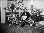 Ruben Jansson omgiven av blommor i hemmet, Östhammar, Uppland