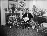 Ruben Jansson omgiven av blommor i hemmet, Östhammar, Uppland