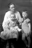 Ateljébild på en kvinna, pojke och spädbarn. Enligt Walter Olsons journal är bilden beställd av fru Ström.