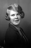 Ateljébild på en kvinna med pärlhalsband. Enligt Walter Olsons journal är bilden beställd av Margit Karlbom.