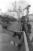 Ekensbergs varv 1970; varvsarbetare inspekterar skador på oidentifierat fartyg.