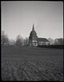 Tidigt under medeltiden uppfördes en kyrka i Tuna. Under 1600-talet byggdes kyrkan ut och genomgick flera renoveringar. År 1737 byggdes ett kyrktorn på västra sidan. År 1764 byggdes en ny sakristia.

Under 1800-talet genomgick kyrkan flera reparationer. Till slut bestämde man sig för att bygga en ny kyrka. För att minska omkostnader behöll man tornet. Nya kyrkan byggdes som ett skal som inneslöt den medeltida kyrkan som revs 1893. Här finns bland annat släkten Hammarskjölds familjegrav.