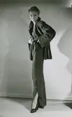 Modell i pälsjacka och kjol med slits.