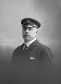 Grosshandlare Erik Kronberg. Levde mellan åren 1870-1930. I mössan det Kungliga Automobil-Klubbens emblem.

