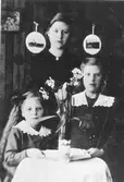 Interiör från uppläggaren August Johannessons lägenhet på Gefle glasbruk.
Från vänster dottern Svea född 1910,
dottern Hildur född 1900 död 1964 och
dottern Gertrud född 1908.
