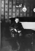 Interiör från uppläggaren August Johannessons lägenhet på
Gefle glasbruk.
I soffan sonen Helmer Johannesson, född 1905.