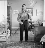 Uppläggarsonen Henning Johannesson med en gardinstång av brunt glas som är tillverkad som så kallad fuskarbete vid Gefle glasbruk.
Stången är 167,5 cm lång och tillhör Johannesson.