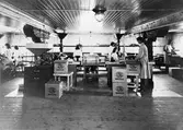 Interiör från kafferosteriet, Isaac Westergren & Co, anlagt 1914.
Paketering av kaffe. Rostmästare Einar Johansson med son.
Kvinnorna arbetade kortare tider.
