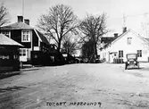 Torget i Brunn 1927.
Från vänster: spruthuset, en fastighet som genom tiderna inrymt diverse affärer och även postkontoret (byggd 1921) numera rivet för beredande av vägen. Caféskylten finns på nuvarande Lundins Bageri, huset med gaveln är Folkets Hus (rivet), huset i fonden är sergant Skoghs (rivet) och det vita huset till höger ägdes av handlare Bäckström och ligger där nuvande Konsum finns.