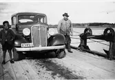 Färjan vid Norra Sundet 1935.
Färjkarlen Anders Andersson (Färkar-Anders).
Bilen (en Chevrolet 1934-1935) är Valfrid Lindbloms taxibil.
Till vänster: Erik Lindblom (son till Valfrid).