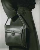 Fransk handväska i brunt skinn med vita stygn.