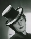 Modell i hatt med hög kulle och brätte. brett hattband, kantband.