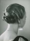 Kvinna med kort, vågig frisyr. Text med blyerts på baksidan: Hygieniska avd. Frisyrer (fru M Oldenburg, Arden)