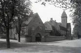 Orig. text: Gamla brandstation, juni 1926.

Gamla brandstationen uppfört 1914-15 efter ritningar av C. E. Rosell, Malmö i nationalromantisk stil. Tillbyggt 1948. Brandsoldaterna skulle bo i och rycka ut ur en borg, som gav intryck av deras farliga och aggressiva yrke.