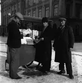 Tidningskiosken på Stora torget. I bakgrunden ses Stora hotellet. Mannen med persianmössa, linköpingsprofilen Konte Säv, skötte försäljningen åt Pressbyrån.