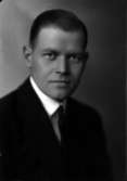 Ateljébild på en man i kavaj. Enligt Walter Olsons journal är bilden beställd av herr Gunnar Holmström.