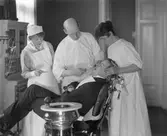 Tandläkare Victor Åhman. Född 1887. Tandläkarmottagningen. Personal och patient.