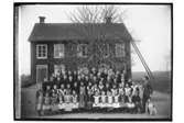 Lännäs skola, tvåvånings skolbyggnad, 61 skolbarn och lärare med hund.
Organist R. Wallin