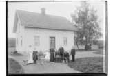 En och en halvvånings bostadshus, nio personer framför huset.
Clas Karlsson