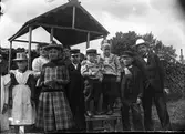 Familjegrupp i trädgård. Mannen till höger i vit hatt är fotografen Karl Östergrens far, Johan Petter Östergren, förman på Rettigs tobaksfabrik i Gävle, innan fabriken monopoliserades.