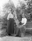 Två unga kvinnor i trädgården






