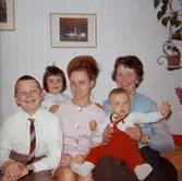 Familjen Jansson sitter samlade år 1965. Från vänster: 11-åriga Christer Jansson (farbror till Lars-Åke), 5-åriga Ilse Tobiasson som sitter snett bakom mamma Ninnie Tobiasson, farmor Maj Jansson (Christers mor) med 1-åriga barnbarnet Lars-Åke Tobiasson i knäet. Lägenheten var en 1:a på Krokslättsgatan 3.