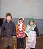 Tre påskklädda kompisar, Jörgen Larsson, Ilse Jansson och Åsa, står uppställda utefter en vägg år 1965. De bodde på Krokslättsgatan 3 i Mölndal.