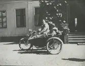 Karin och Bertil Uggla på motorcykel med sidovagn vid Tuna gård.