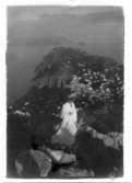 Ester Ellqvist-Bauer står på en klippa med utsikt över Capri i Italien.