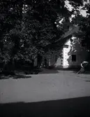 Trädgårdsflygeln på Tuna gård. En person krattar grus.