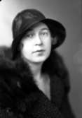 Ateljébild på en kvinna i hatt och kappa. Enligt Walter Olsons journal är bilden beställd av fru Lisa Winbladh.