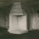 Interiör med putsad spis och vägg.