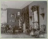 En salong i Sven Carlsbergs hem med bland annat möbler, tavlor och ljusstakar.