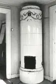 Kakelugn på övervåningen i en fastighet. Den är utförd i rokokopastisch i bland annat rosa, blått och grönt. Huset rivet 1971.