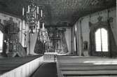 Interiör av Frödinge kyrka. Man ser altaret, ljuskrona, predikstol, nummertavla och kyrkbänkar.