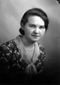 Ateljébild på en kvinna i klänning och i en scarf. Enligt Walter Olsons journal är bilden beställd av Elin Frödén.